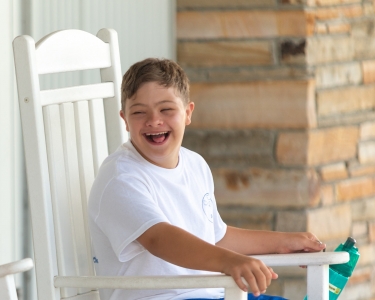 Camper from Camp SOAR enjoying time with friends on our rocking chairs outside of the dining hall.
Photo by: Beyond Memory Photography